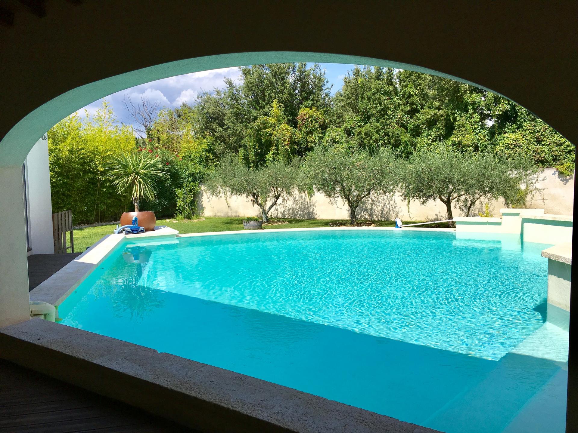 Vue piscine depuis le coin repas terrasse couverte à l'extérieur